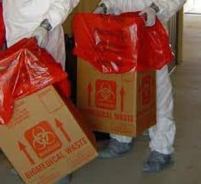 Hazmat Cleanup crew dressed in PPE disposing of biohazard waste caused by an unattended death in Broward County, Florida.